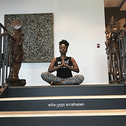 An African American woman seated in meditation at the top of a staircase