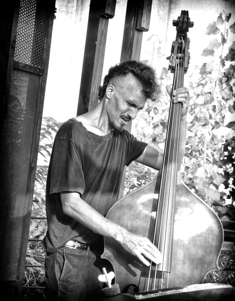 A black and white photo of a man playing the upright bass