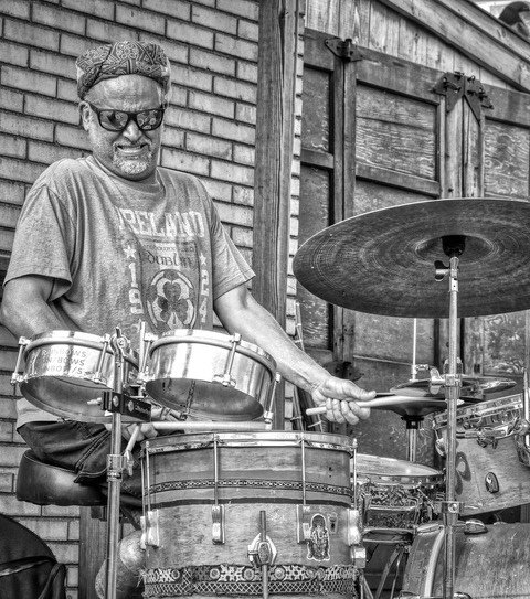 A black and white photo of a man playing the drums 