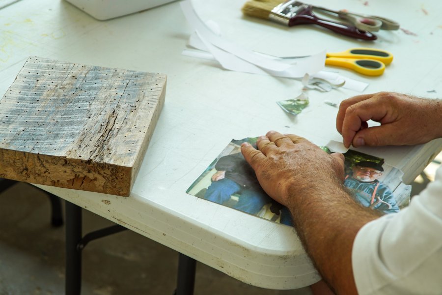 A man's hands working on an art project