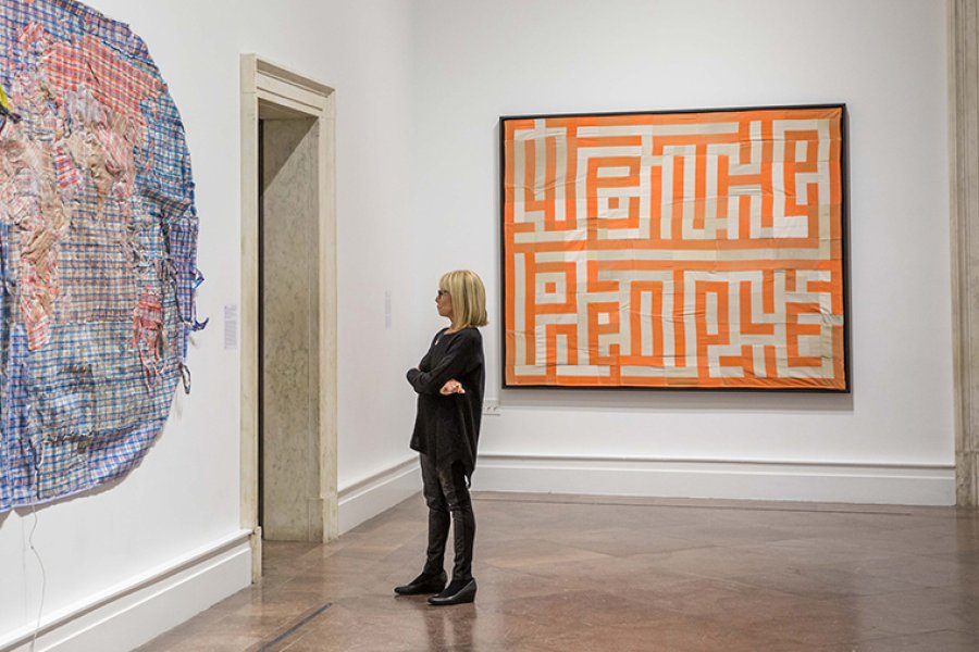 A woman looking at large works on the walls