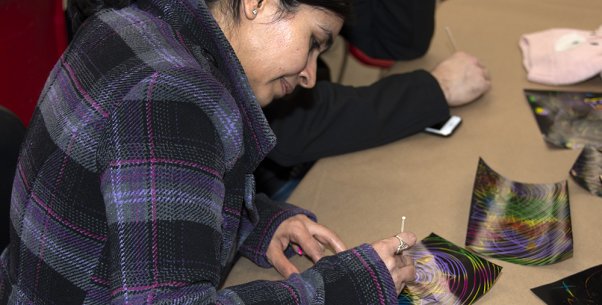 A woman seated at a table doing an art activity
