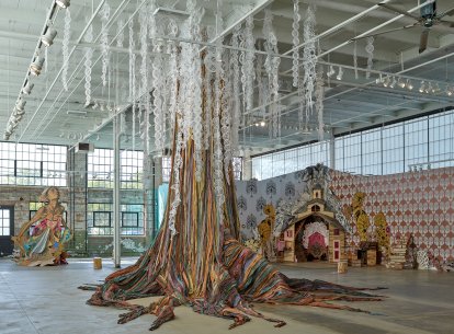 Installation view of several large sculptures, including a tree made from fabric in the foreground