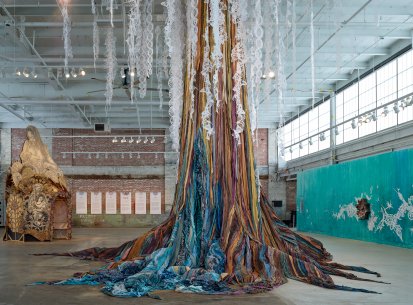 A large tree sculpture made out of strips of dyed fabric