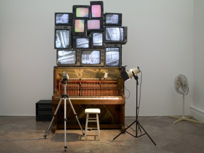 A piano with TV screens sitting on top of it