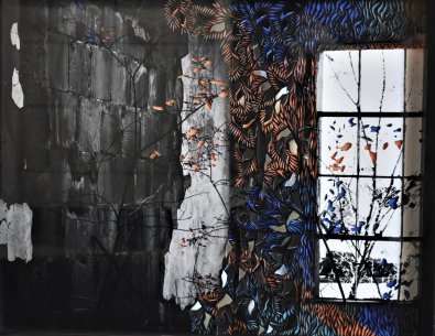 A black and white photograph of a concrete wall and window with colorful cut paper on top