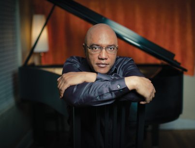 Billy Childs sits in front of a piano
