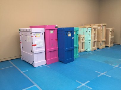 Wooden crates of different colors lined up against a wall