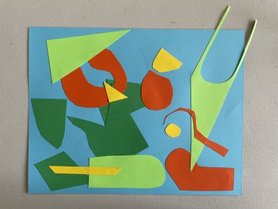 A collage of dark green, light green, red, and yellow pieces of paper on a blue background