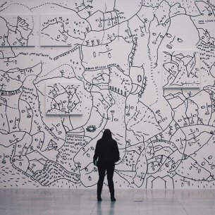 Silhouette of a person looking at Shantell Martin&#039;s mural