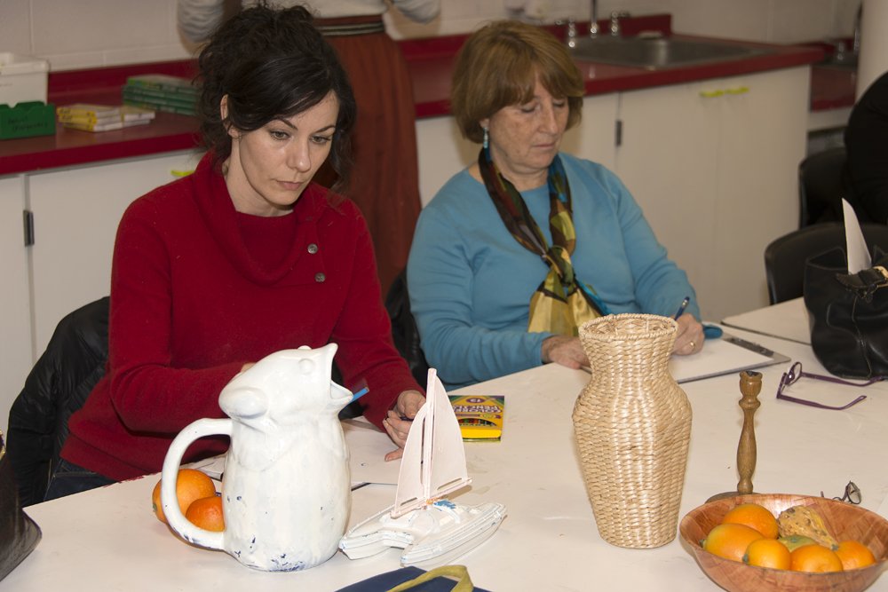 Two women make still life drawings in the education classrooms