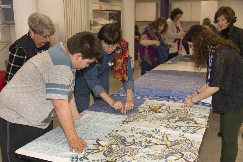 Amanda Browder and participants sew large swaths of fabric