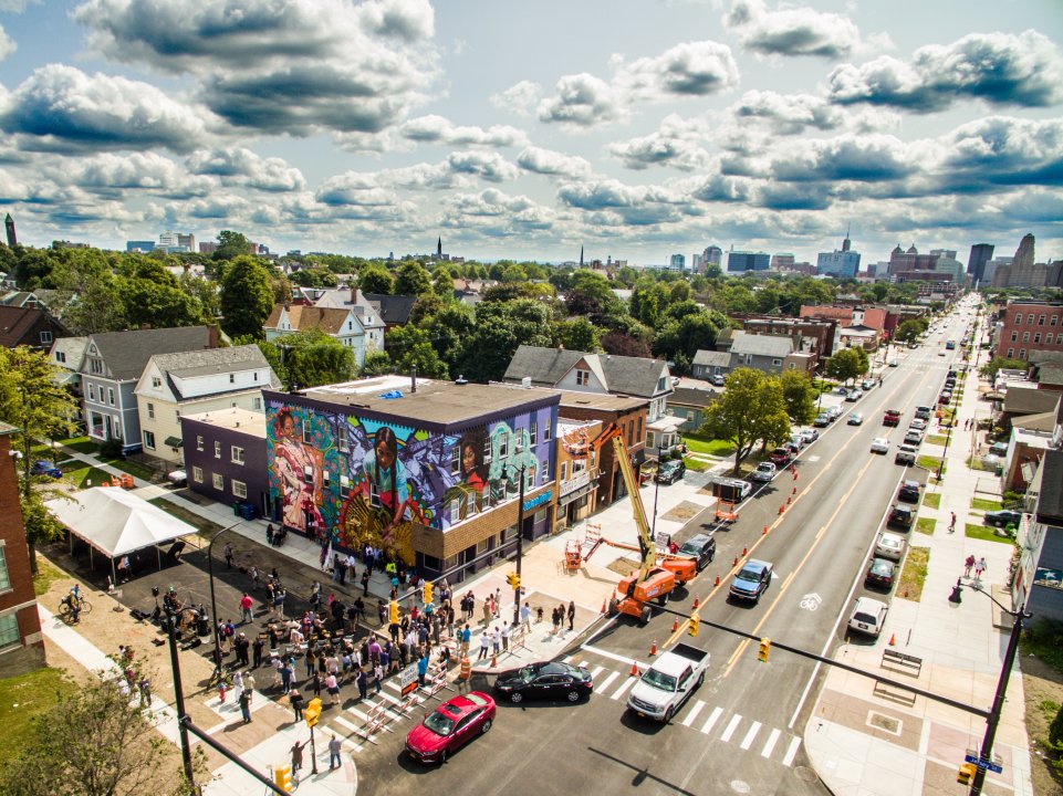 Aerial view of the community dedication celebration for Betsy Casañas&#039;s Patria, Será Porque Quisiera Que Vueles, Que Sigue Siendo Tuyo Mi Vuelo (Homeland, Perhaps It Is Because I Wish to See You Fly, That My Flight Continues To Be Yours) at 585 Niagara St