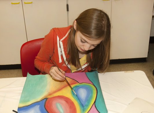 A girl painting in the classroom