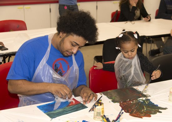 Father and daughter creating art in the classroom