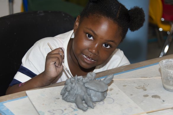 A Black girl making a clay sculpture