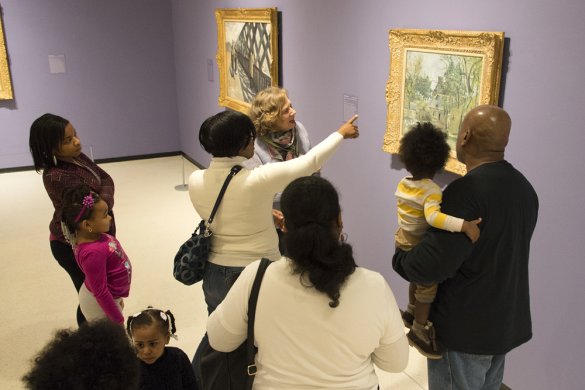 A docent leads families on a tour of the museum