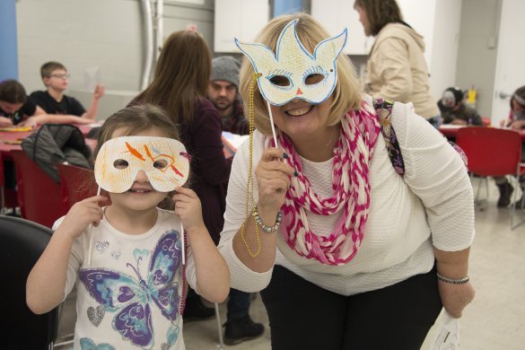 A mother and daughter wearing masks they created