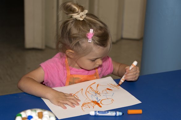 A young girl drawing in the classroom
