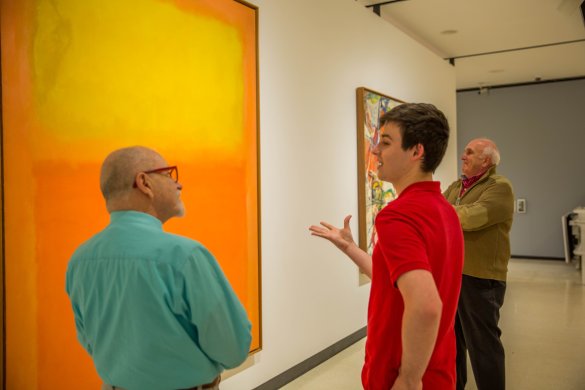 Three men standing in front of Mark Rothko's Orange and Yellow
