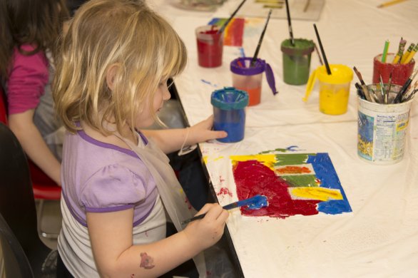 A young girl painting in the classroom
