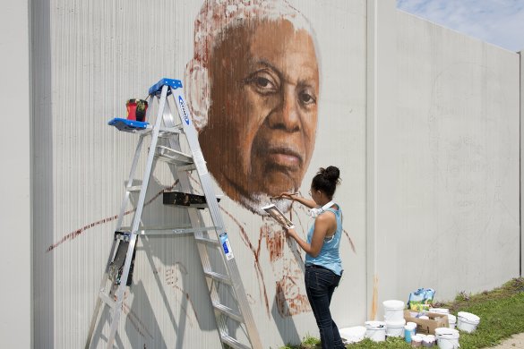 Julia Bottoms working on a portrait of Arthur O. Eve for The Freedom Wall