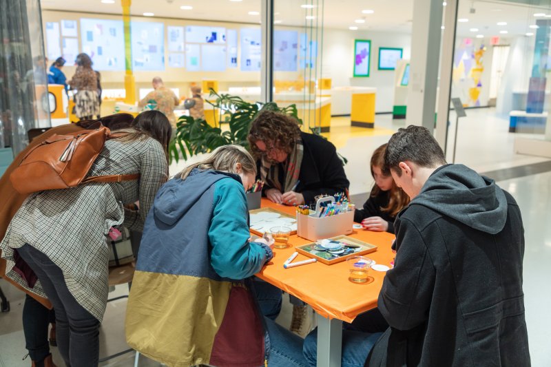 People working on an art project at an orange table