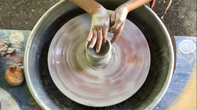 Student creating a work on a pottery wheel