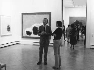 Black-and-white photograph of Cleve Gray standing with another person in the middle of a gallery