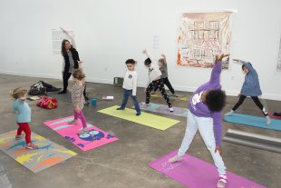 Kids doing yoga in a large room