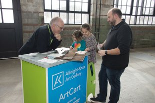 Two men and two young girls explore materials on the ArtCart