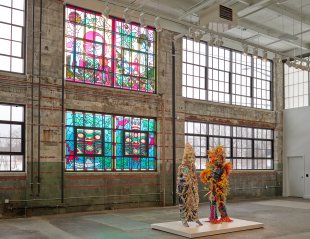 Two human-sized costumes and four faux stained glass windows in the background