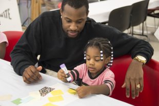 A man and his daughter making art in the classroom