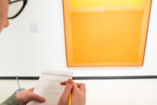 A poet from Just Buffalo Writing Center creates a made-to-order poem in front of Mark Rothko&#039;s Orange and Yellow, 1956