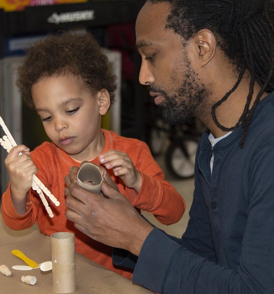 An African American father and son making a sculpture