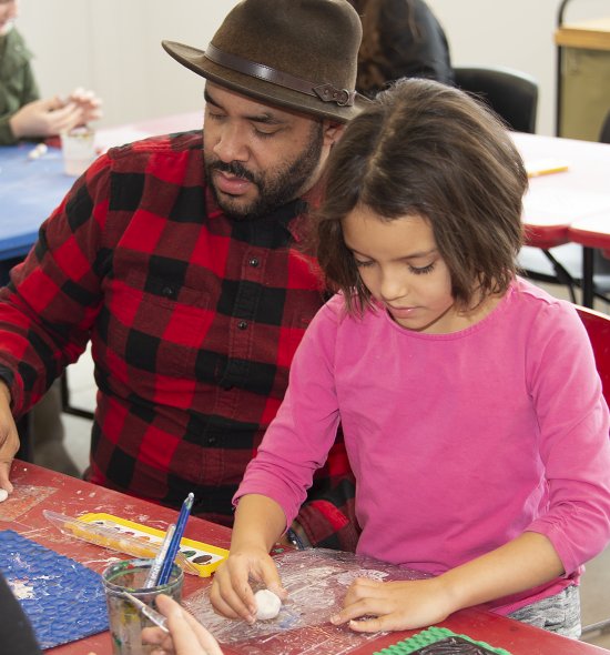 A man and girl making art in a classroom