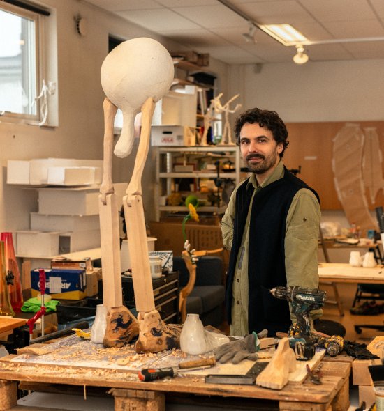 A man in a studio working on a sculpture