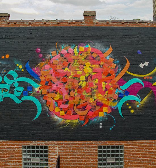 A mural featuring calligraphic forms in different colors on a black background