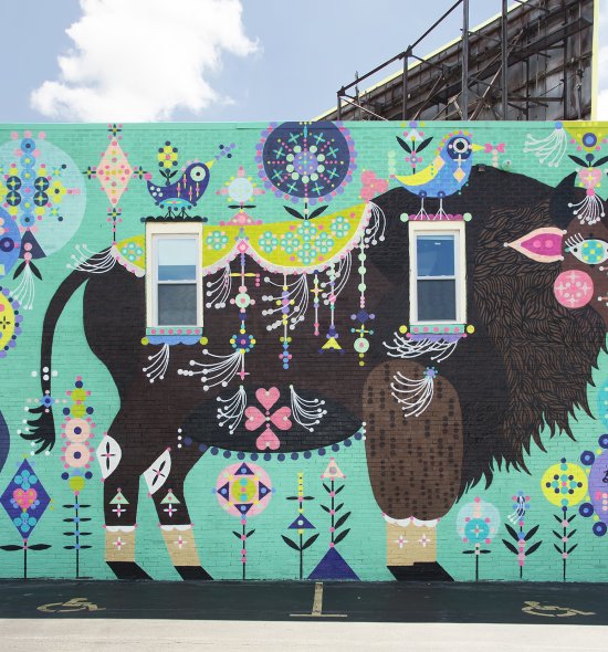 A large mural featuring a large brown buffalo surrounded by green and purple designs