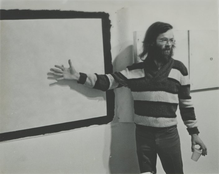 Tony Conrad in front of Yellow Movie 2/2/73, 1973, and two Yellow Movie—35mm Format canvases from 1973 in his retrospective exhibition at Hallwalls Contemporary Arts Center, Buffalo, New York, December 1977
